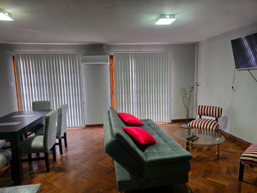 een woonkamer met een groene bank en een tafel bij Punta Blanca in Salta