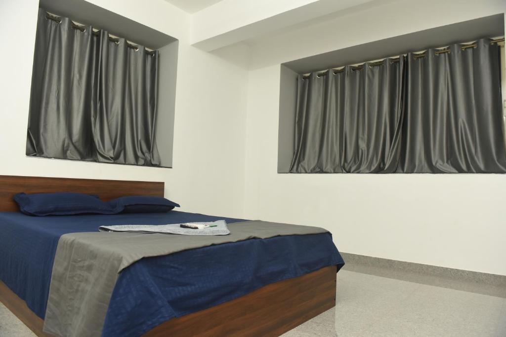 a bedroom with a bed and two windows at Sai Homestay Panaji 2 BHK and Studio Apartment in Panaji