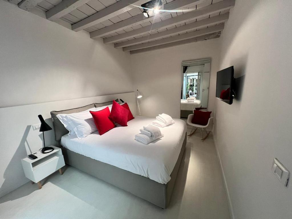 ein Schlafzimmer mit einem großen weißen Bett mit roten Kissen in der Unterkunft NEW Ground Floor apt and PATIO in Florenz