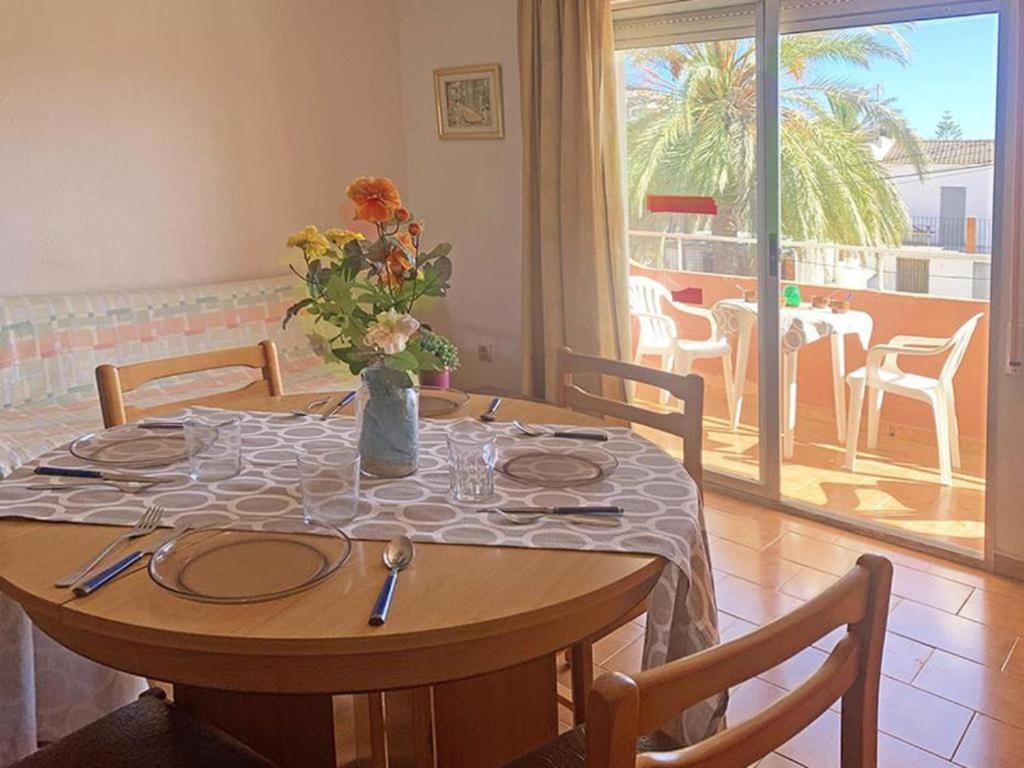una mesa de comedor con un jarrón de flores. en Apartamentos Mar de Peñíscola Casablanca 3000, en Peñíscola