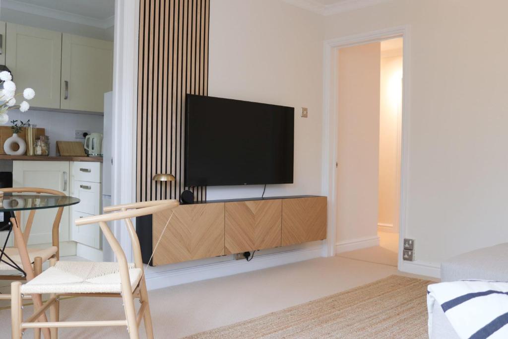 a living room with a flat screen tv on a wall at Hidden Oxford Haven with Free Parking in Oxford