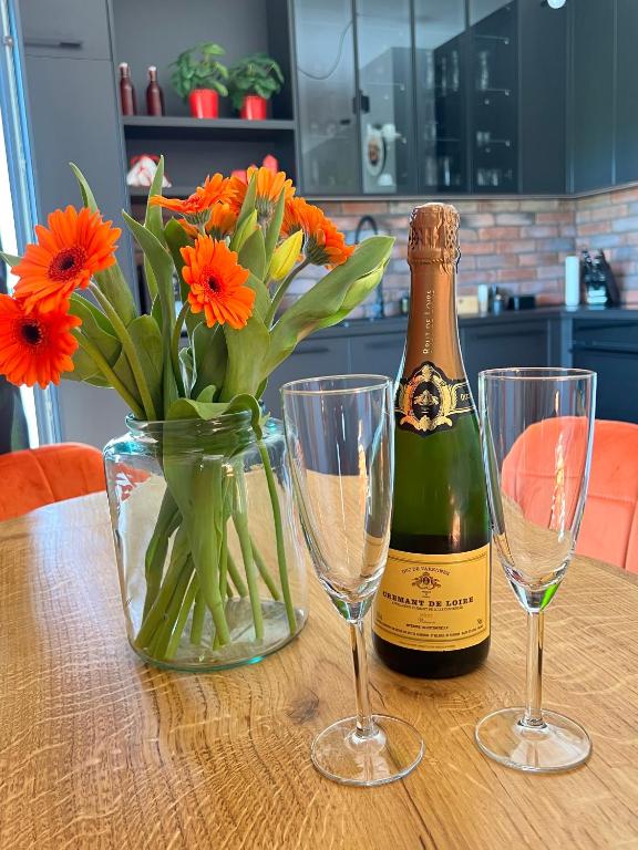 a bottle of champagne and two glasses on a table at Silesia Apartments Ustron B129 in Ustroń