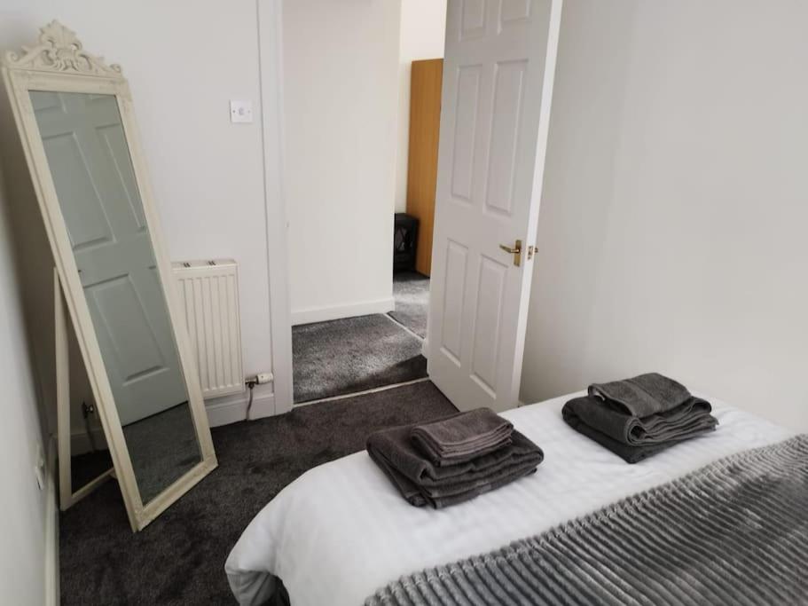 1 dormitorio con 1 cama con 2 toallas en M Rooms - entire 1 bedroom, furnished pub flat, en Kirk of Shotts