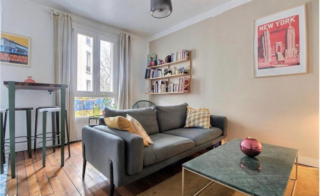 a living room with a couch and a table at Appartement cosy Clichy in Clichy