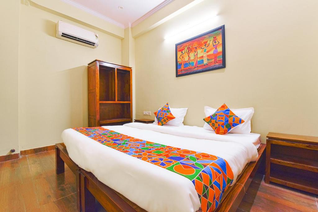 a bedroom with a large bed with a colorful blanket at GMI Hotel and Benquet Jaipur in Jaipur