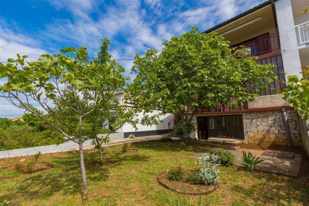 una casa con un patio con dos árboles delante de ella en Ferienwohnung für 6 Personen ca 56 qm in Jadranovo, Kvarner Bucht Crikvenica und Umgebung, en Jadranovo
