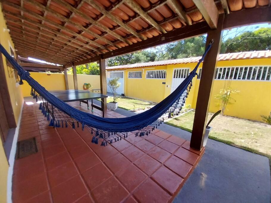 een hangmat op de patio van een huis bij Casa ampla, arejada, muitos jogos e quarto cinema! in Rio das Ostras