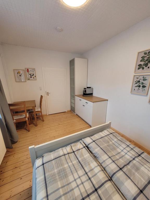 Un dormitorio con una cama y una mesa. en Ruhige, kleine Unterkunft in Weyhe, Nähe Bremen, en Weyhe