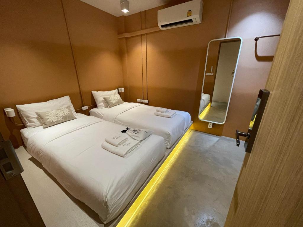 バンコクにあるThe Palette Bangkok Hotel - Self check-in after 10 pmの小さな部屋で、ベッド2台、鏡が備わります。