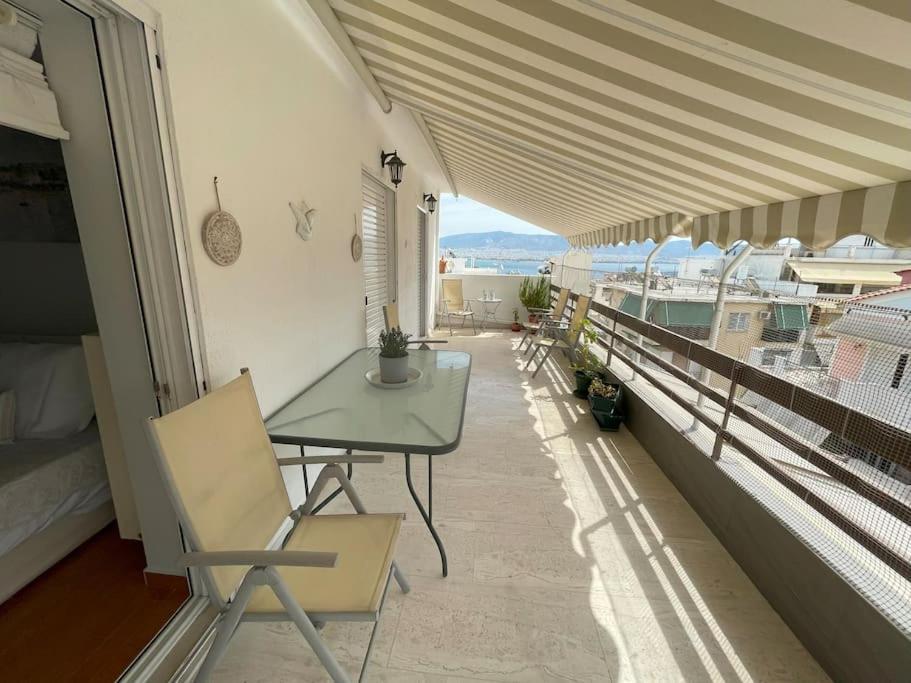 einen Balkon mit einem Tisch und Meerblick in der Unterkunft Alexandra's View in Piräus
