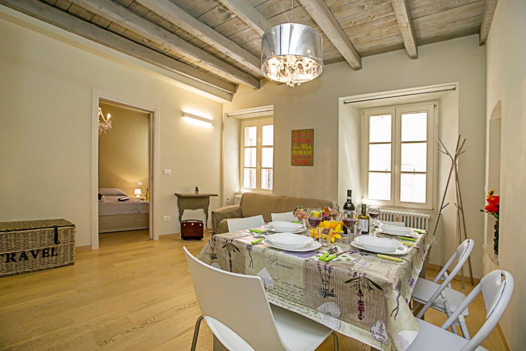 a dining room with a table and white chairs at Residenza Il Cavaliere del Lago - Happy Rentals in Riva del Garda