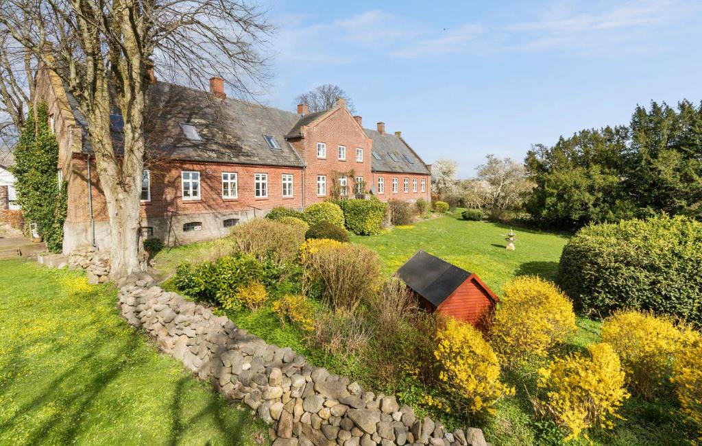 une grande maison en briques avec un jardin en face de celle-ci dans l'établissement Pet Friendly Home In Rnde With Kitchen, à Rønde