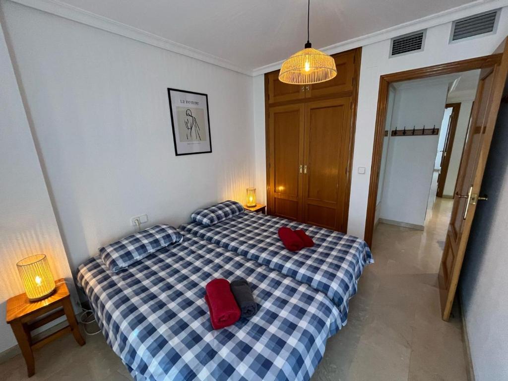 ein Schlafzimmer mit einem Bett mit zwei roten Kissen darauf in der Unterkunft Appartement Pedraza in Albir