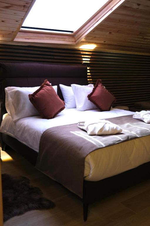 a bedroom with a large bed with red and white pillows at AYDOĞDU SUİT OTEL in Bolu