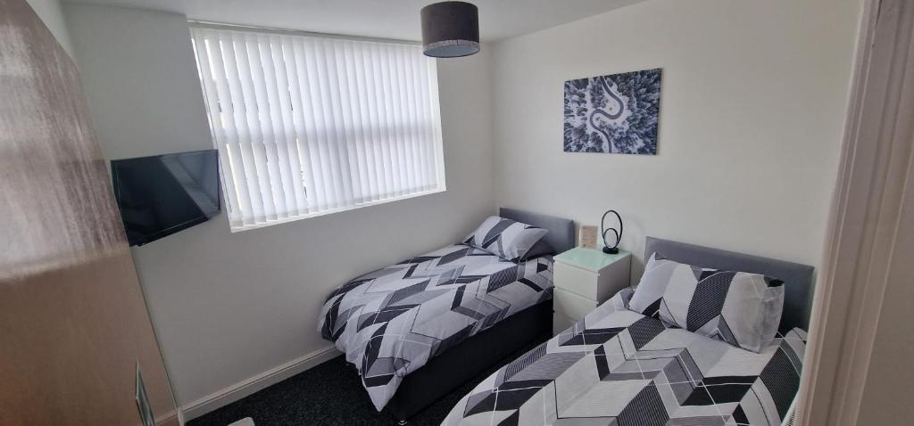 a bedroom with two beds and a window at LFC Anfield Guest House in Liverpool