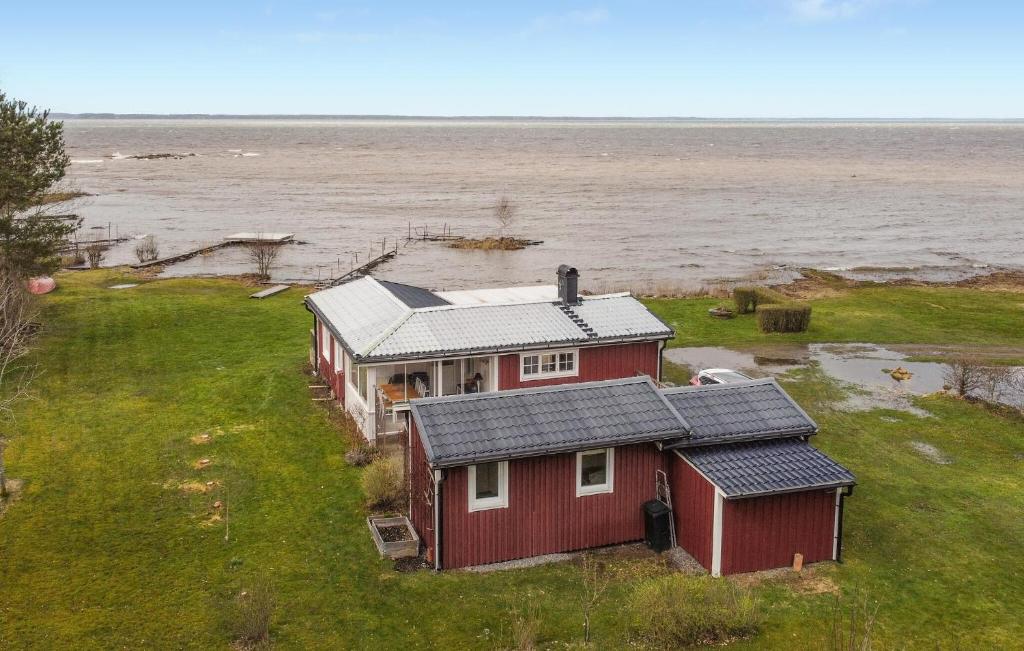 a red house on the shore of a body of water at 3 Bedroom Pet Friendly Home In Kllby in Källby