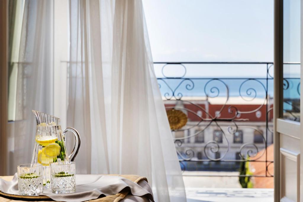 uma mesa com uma jarra de limonada e copos. em Mediterranean Palace em Tessalônica