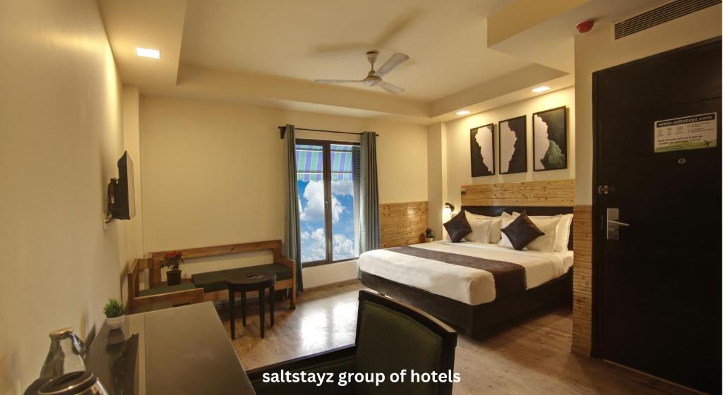 una camera d'albergo con letto e scrivania di Saltstayz Thyme - New Friends Colony a Nuova Delhi
