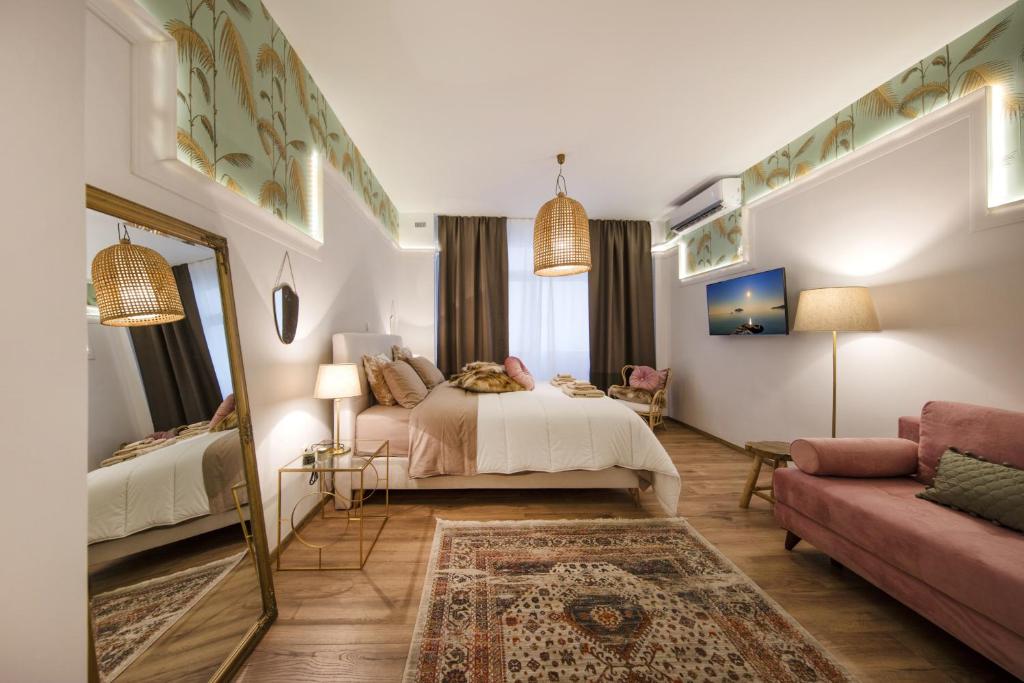 - une chambre avec un lit, un miroir et un canapé dans l'établissement Exquisite apartment in the center of Athens, à Athènes