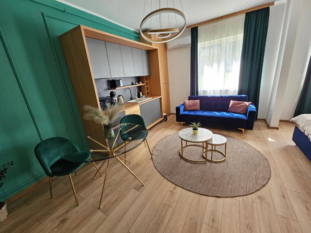 een woonkamer met een blauwe bank en een tafel bij POT Apartments in Târgu-Mureş