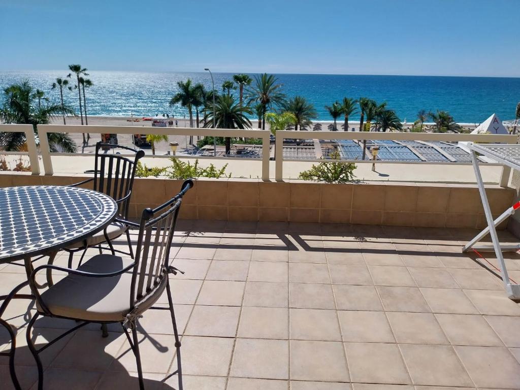a patio with a table and chairs and the beach at Home4Holidays in Nerja