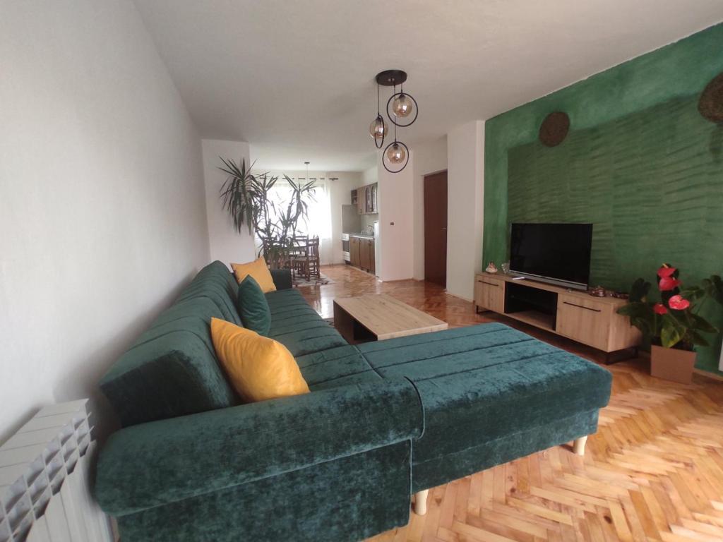 a living room with a green couch and a television at REA Home Visoko in Visoko