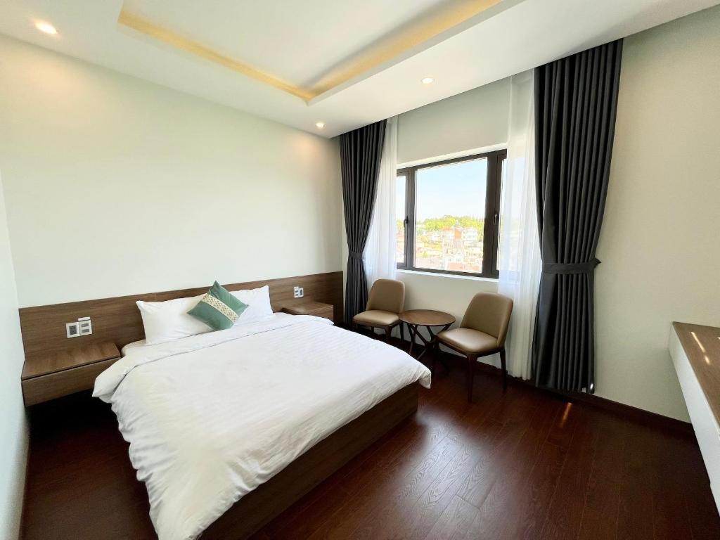 a hotel room with a bed and a window at SAFFRON Dalat in Da Lat