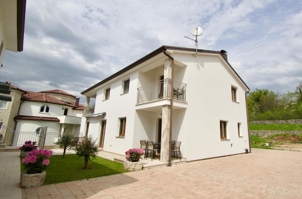 un gran edificio blanco con balcón. en Apartmani Rajković, en Matulji