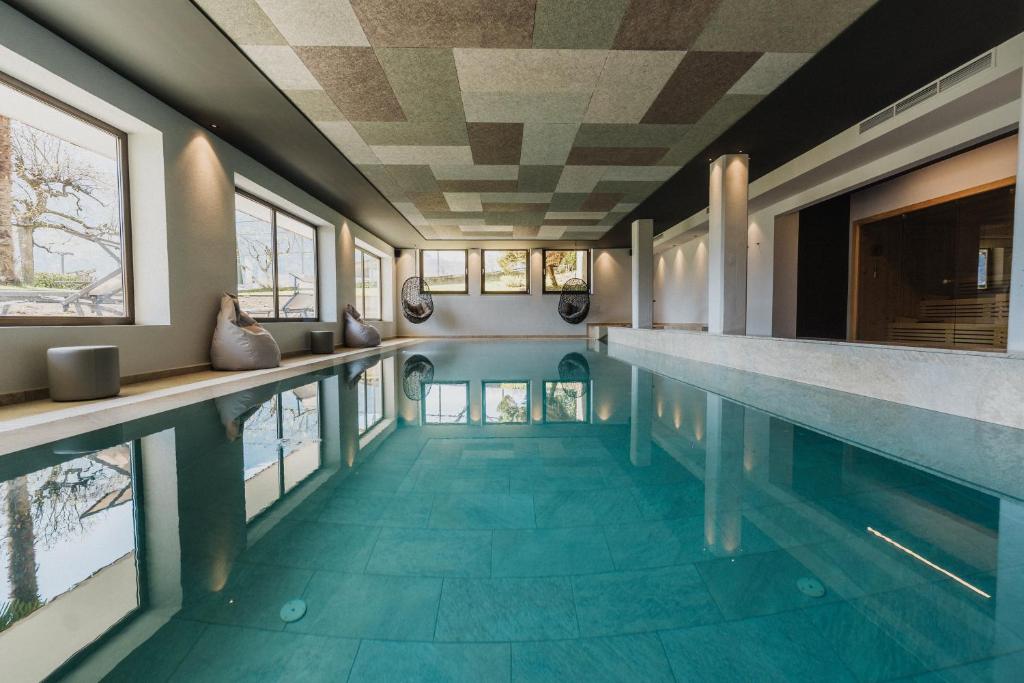 una piscina con suelo de baldosa azul y ventanas en Thalguter - Rooms & Breakfast, en Lagundo