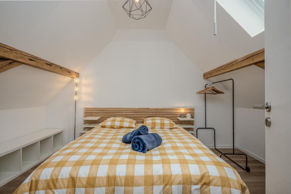 a bedroom with a bed with a checkered blanket at Une petite vue sur le Paradis in Orbey