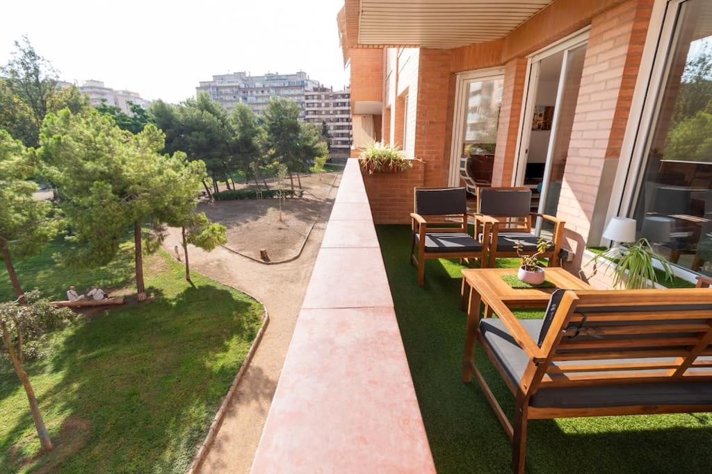 eine Terrasse mit Holzstühlen und Tischen auf einem Haus in der Unterkunft Apartamento en Parque Central in Tarragona