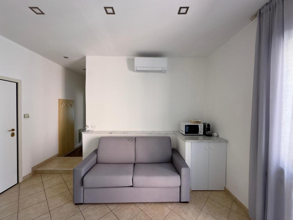 uma sala de estar com um sofá e um micro-ondas em Appartamento La Mola em Varazze