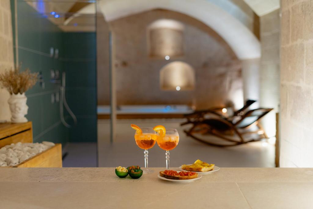 two glasses of wine sitting on a counter in a kitchen at Endea Suite Rooms & Lounge SPA in Matera