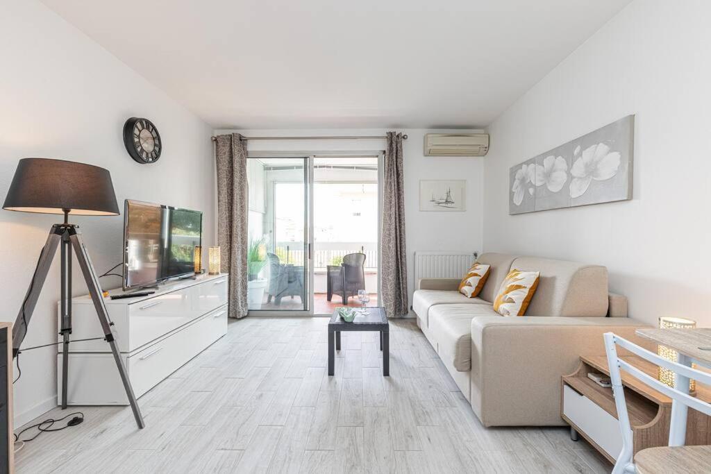 ein weißes Wohnzimmer mit einem Sofa und einem TV in der Unterkunft Beau studio avec terrasse ensoleillée - Proche mer in Cagnes-sur-Mer