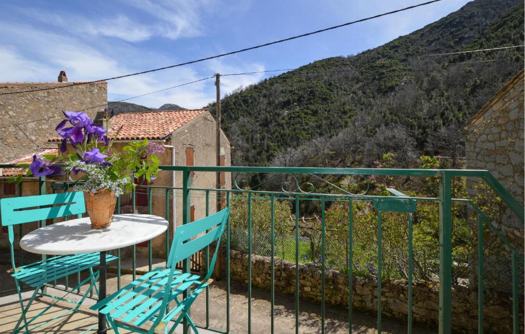 una mesa y sillas en un balcón con un jarrón de flores en Stunning Home In Marignana With Kitchen, en Marignana