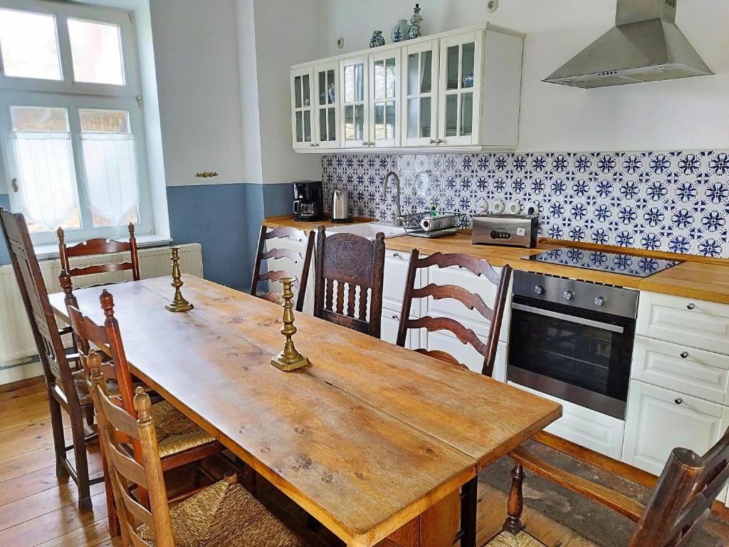 uma cozinha com uma mesa de madeira e um fogão forno superior em Fährhaus Wittower Fähre em Wiek auf Rügen