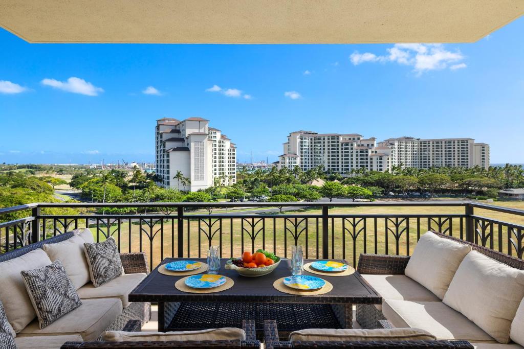 a balcony with a table with a bowl of fruit on it at Ko Olina Beach Villas O724 in Kapolei
