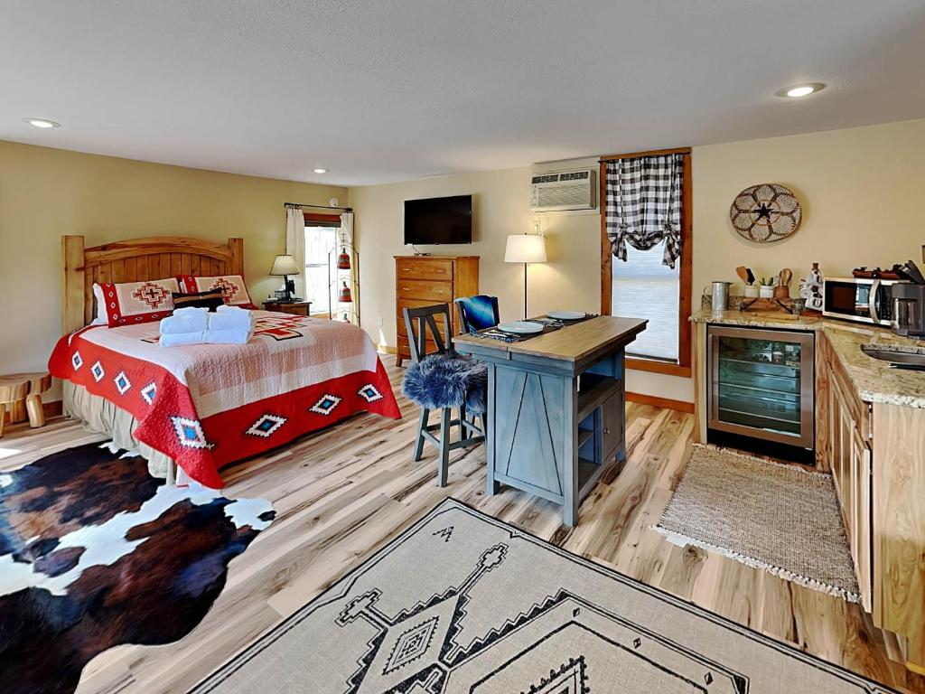 a bedroom with a bed and a desk and a kitchen at Double Eagle 2 in Alto