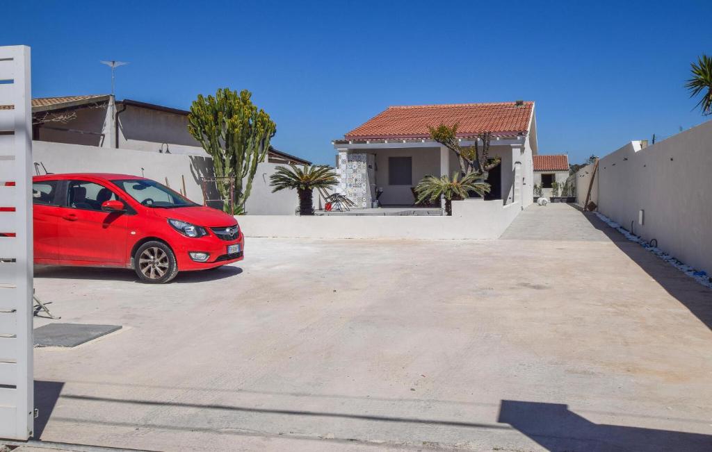 ein rotes Auto, das vor einem Haus parkt in der Unterkunft Nice Home In Santa Maria Del Focall With Wifi in Santa Maria Del Focallo