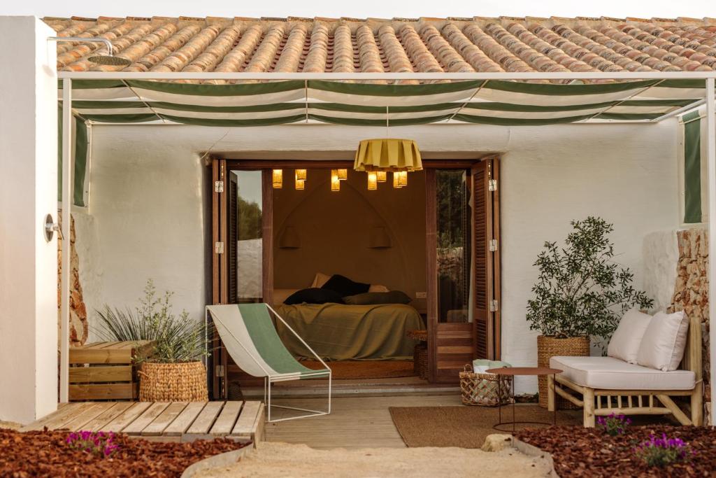 une terrasse couverte avec un lit et une chaise. dans l'établissement Amagatay Menorca, à Alaior