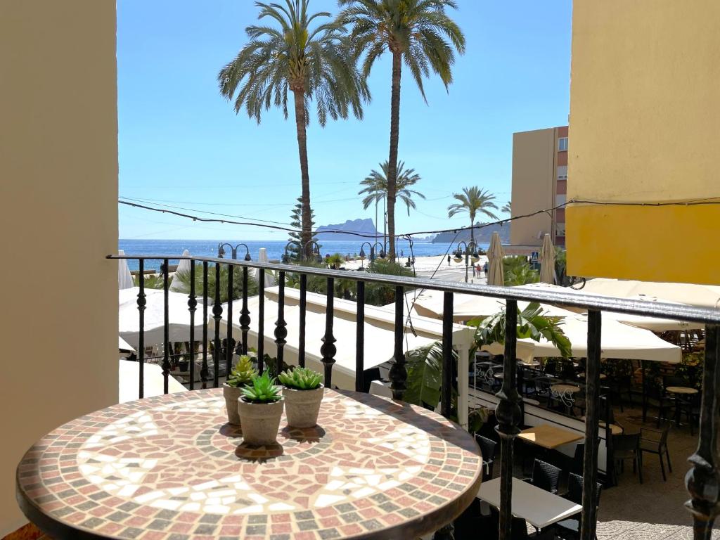 a table on a balcony with a view of the beach at Castillo de Moraira in Moraira
