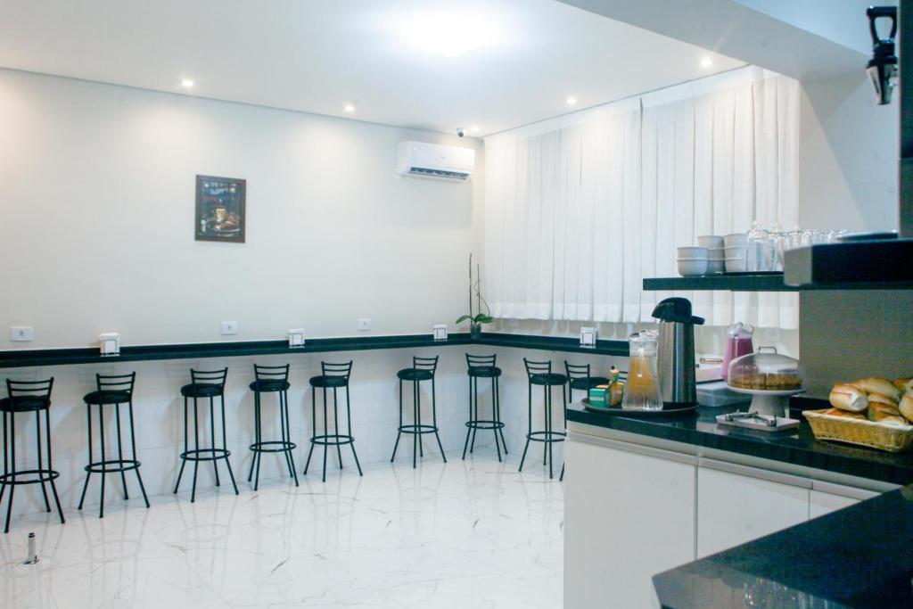eine Küche mit einer Theke mit Barhockern in der Unterkunft Hotel New House in São Paulo