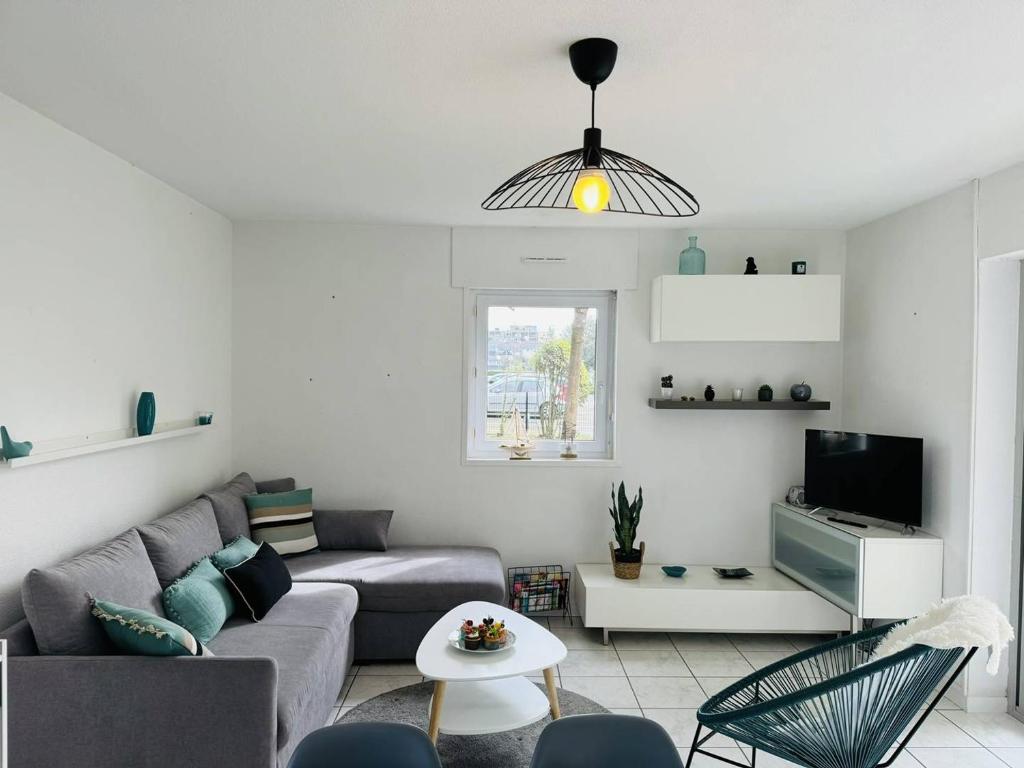 un salon avec un canapé et une table dans l'établissement Appartement confortable, 2 chambres, proche plage, à Carnac