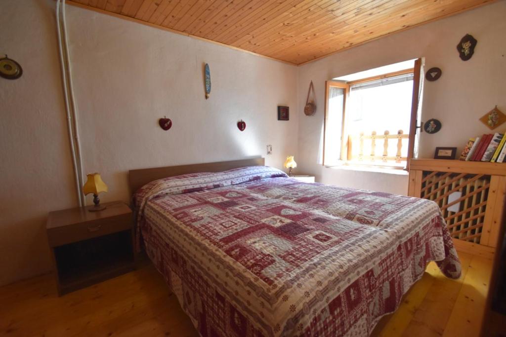 a bedroom with a bed in a room with a window at Casa Canale in Tonezza del Cimone
