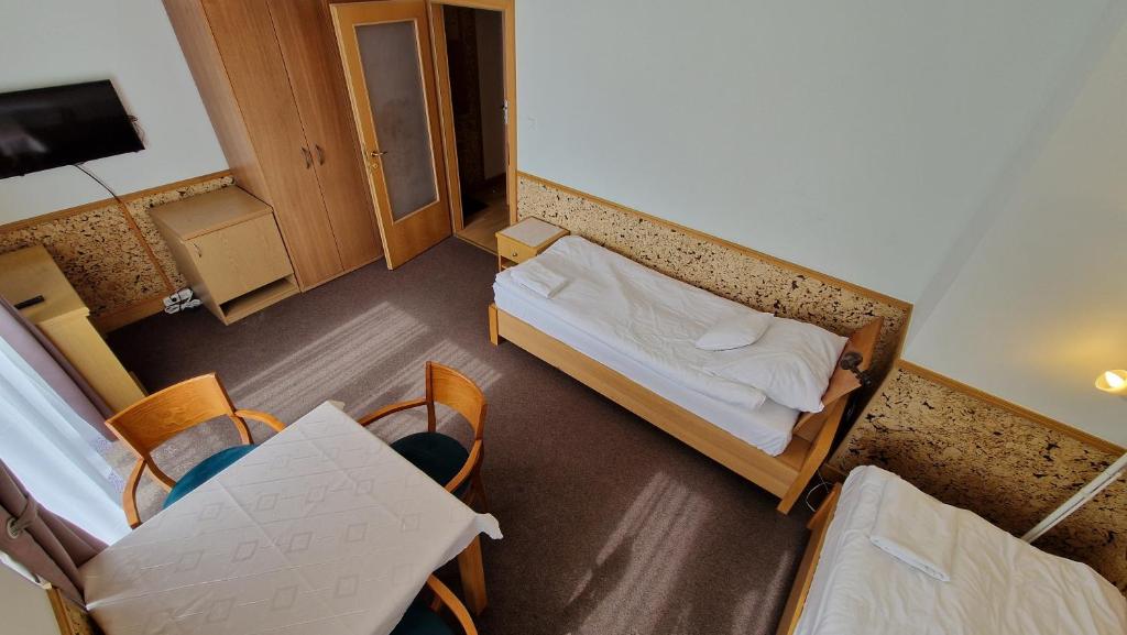 ムシナにあるPokoje Gościnne Muszyna przy sądzieのベッド、テーブル、椅子が備わる小さな客室です。