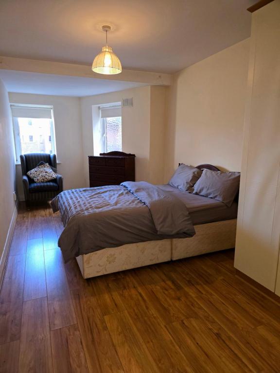 een slaapkamer met een bed en een stoel erin bij Gracian OMB Dublin Apartment in Dublin