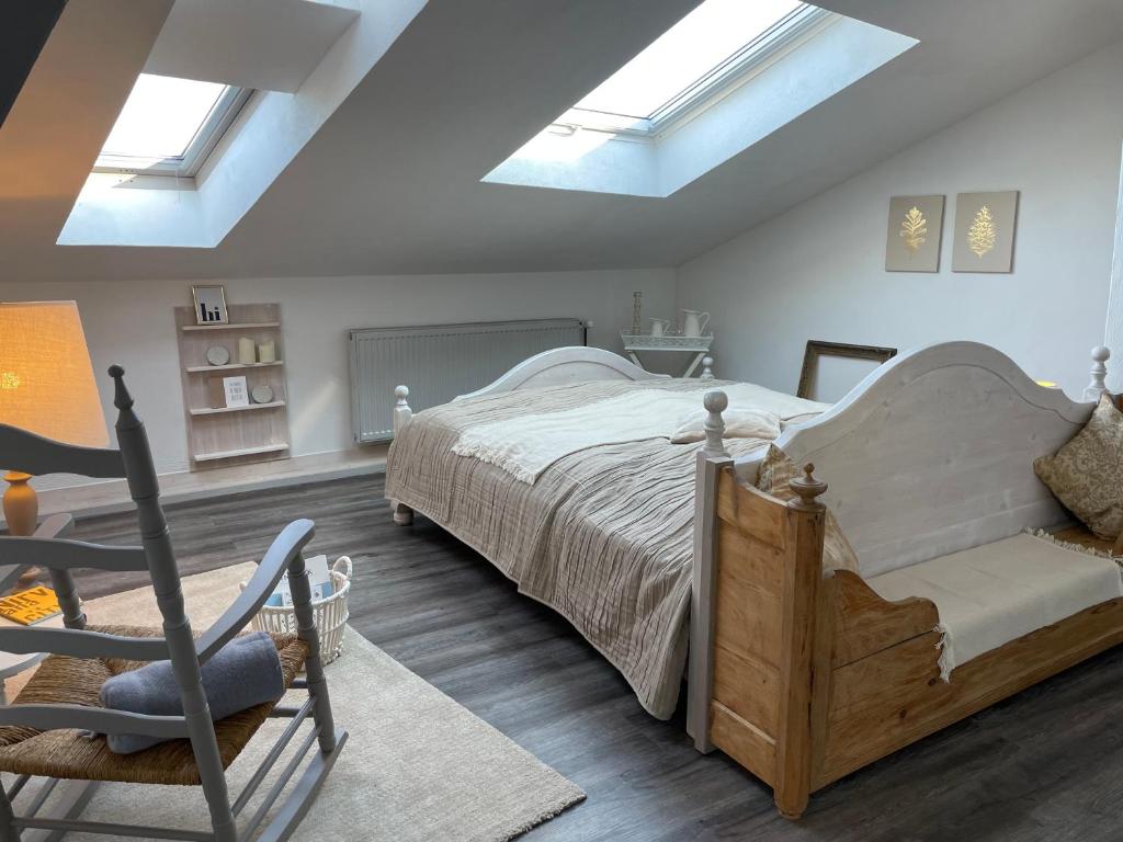 a bedroom with a bed and a chair and skylights at Altstadt-Gästehaus mit Garten. Und Herz. in Bad Kreuznach