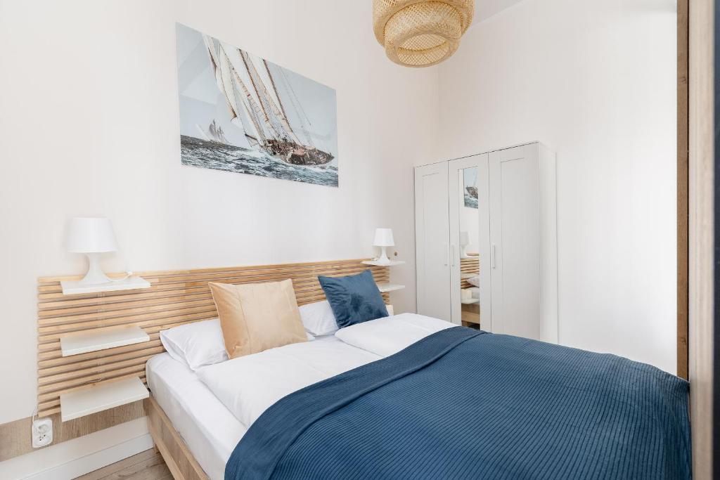 a bedroom with a bed with a blue blanket at Modern Studio with Terrace and Parking in Swinoujscie in Świnoujście