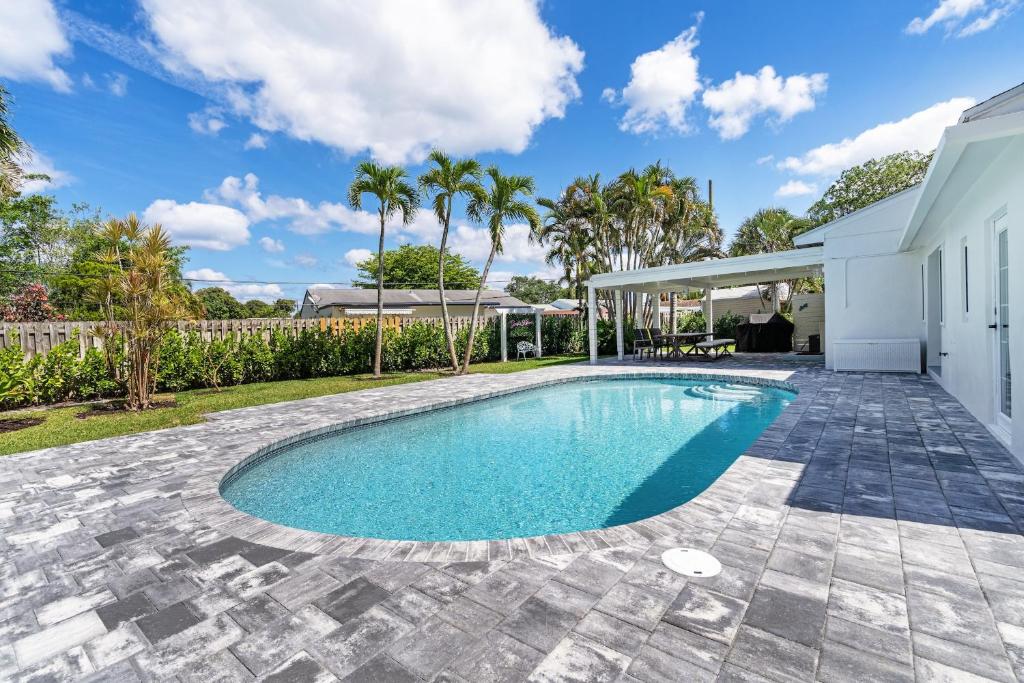 a swimming pool in the backyard of a house at Delray Oasis: Pool, Gazebo & Beach Access in Delray Beach