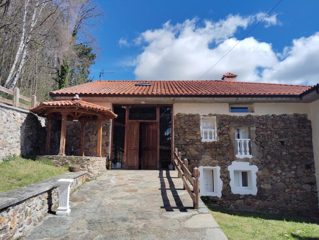 Casa de piedra con puerta y pared de piedra en Hotel El Nuevo Semellon 